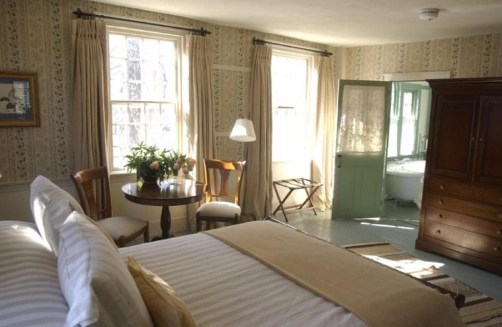 1 dormitorio con 1 cama grande y baño en The Old Inn On The Green, en New Marlborough