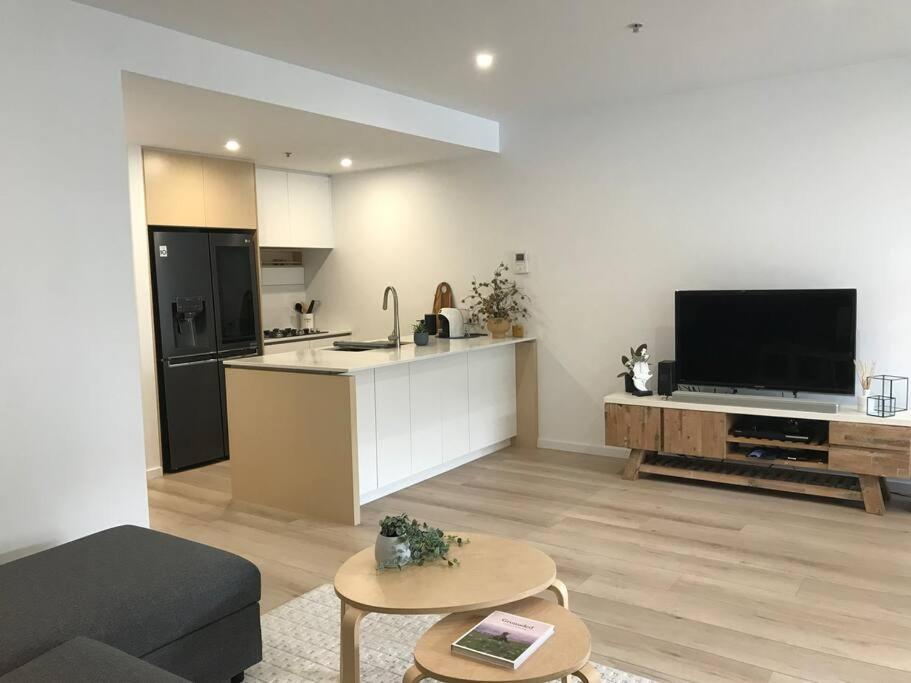 a kitchen and living room with a couch and a table at In the Heart of Port Melbourne in Melbourne