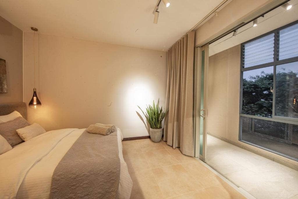 a bedroom with a bed and a large window at Anaya Living - Colombo 03 in Colombo