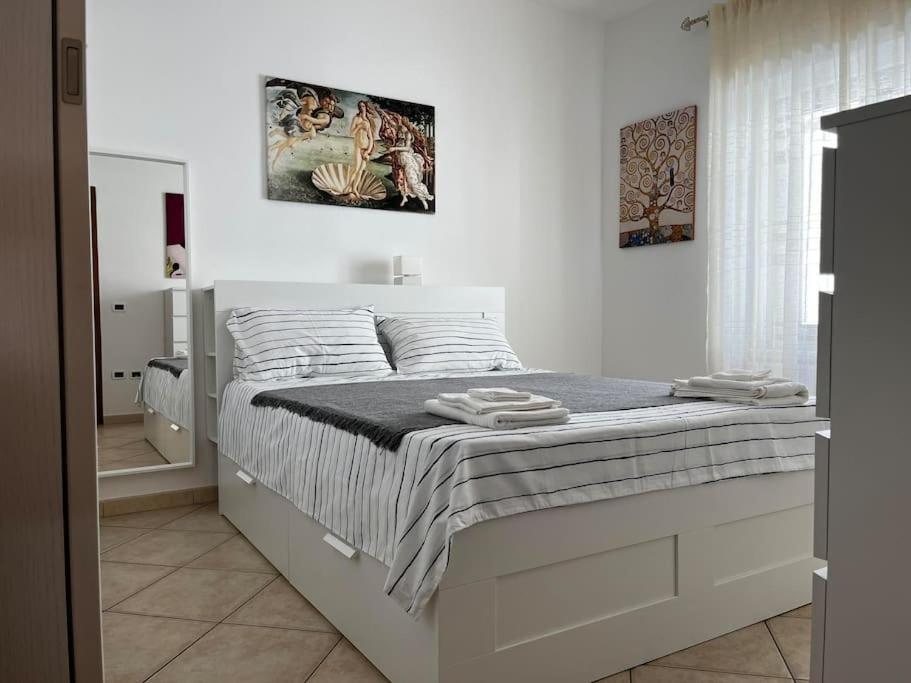 a white bedroom with a bed with towels on it at Sardegna: mare e montagna IUN R0346 in Oliena