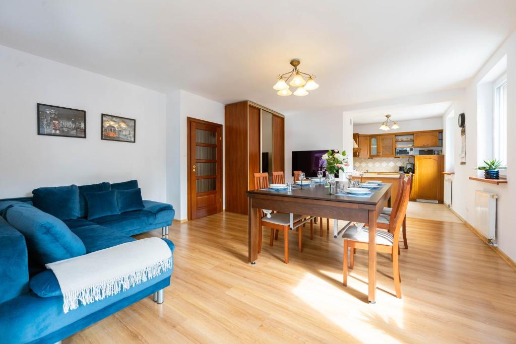 - un salon avec un canapé bleu et une table dans l'établissement Apartament Bukowy z bilardem, à Wisła