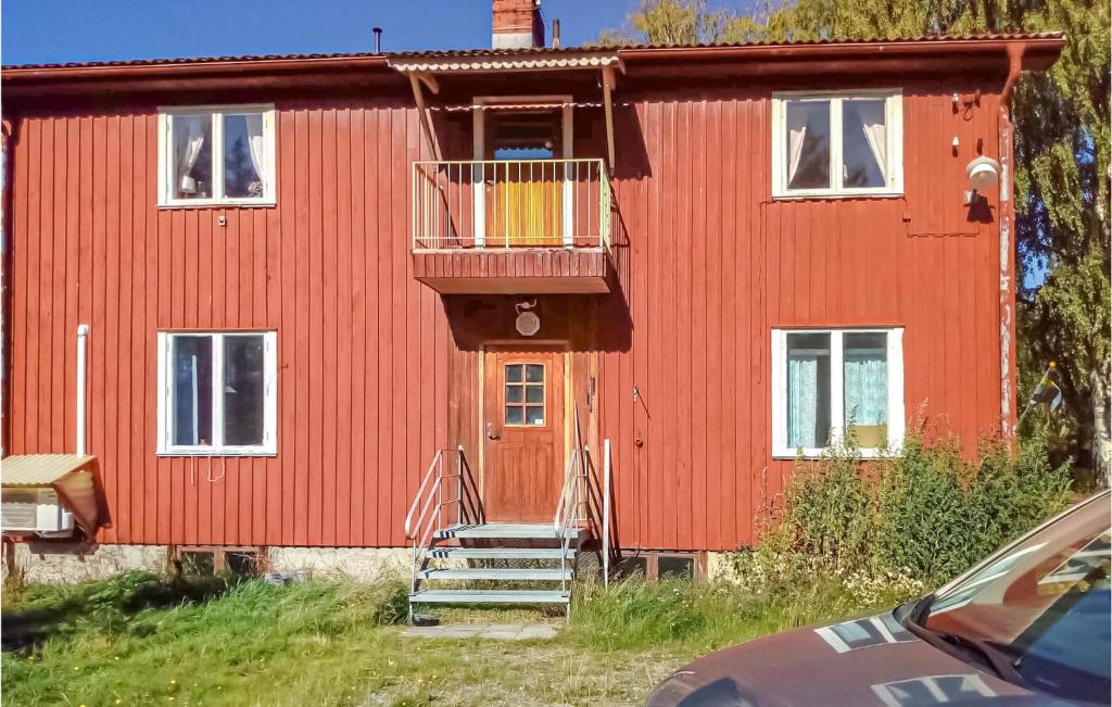 a red house with a balcony in front of it at Amazing Apartment In Boliden With Kitchen in Boliden