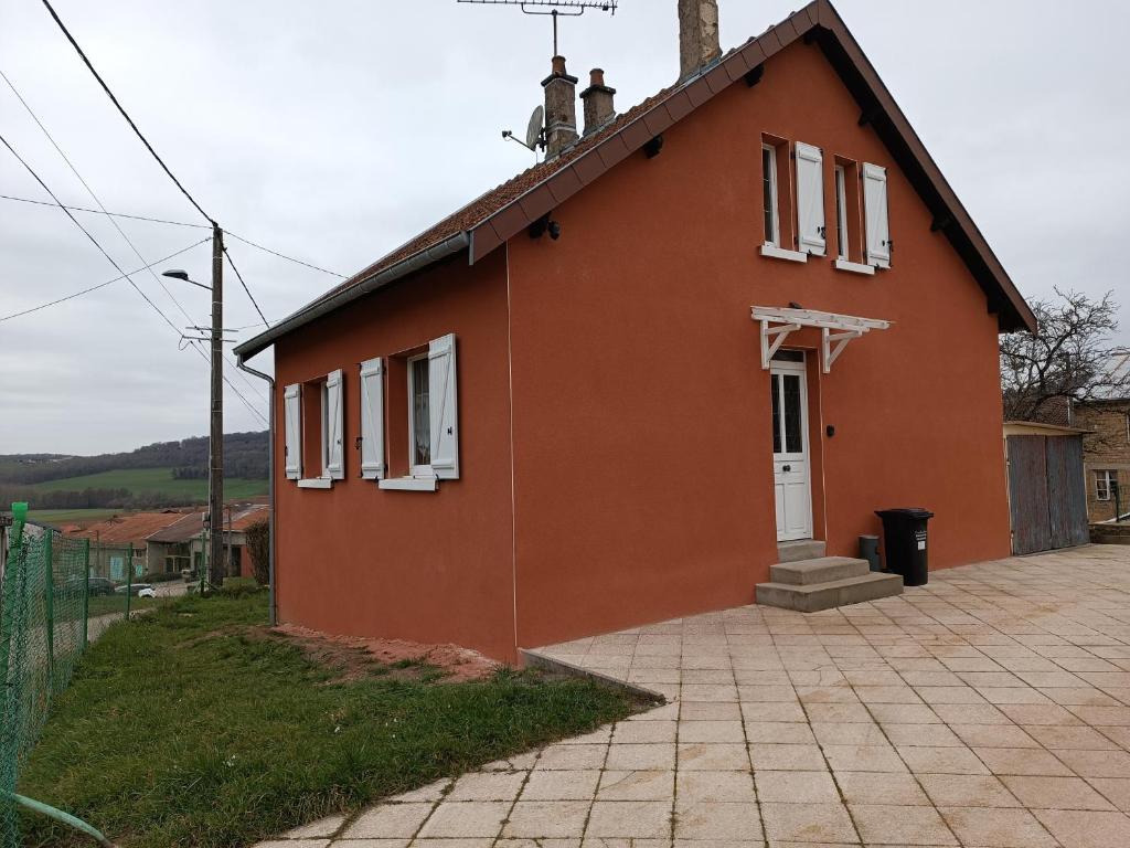 ein kleines orangenes Haus mit einer weißen Tür in der Unterkunft Gîte Thomas et Joanie in Moulins-Saint-Hubert