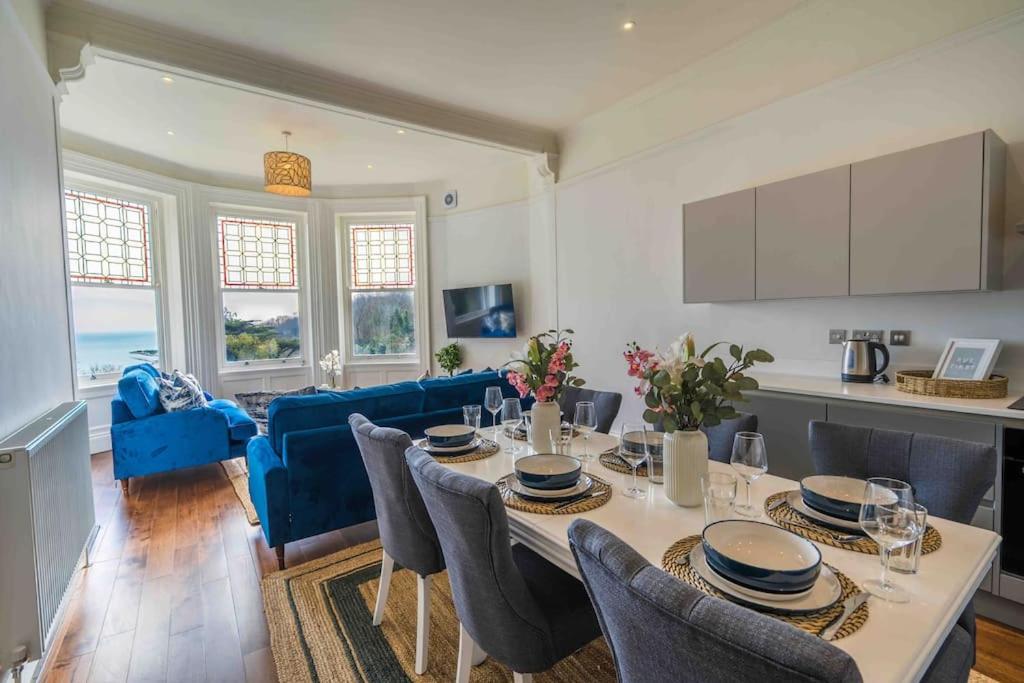 kuchnia i salon ze stołem i krzesłami w obiekcie Beautiful Beach side Apartment w mieście Torquay
