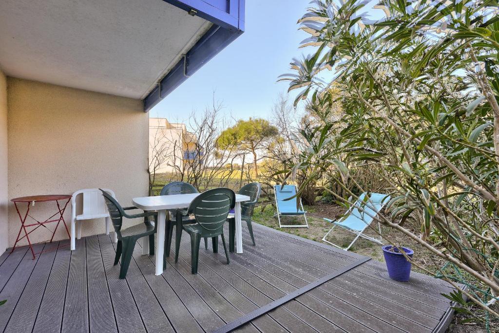 un patio con mesa y sillas en una terraza en Bord de mer, a 250 m de la plage a Lacanau, en Lacanau