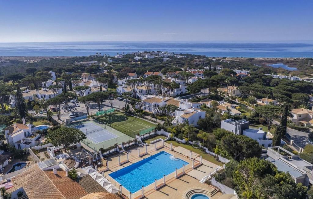 an aerial view of a villa with a pool and a tennis court at Casa Julia - Dunas Douradas in Faro