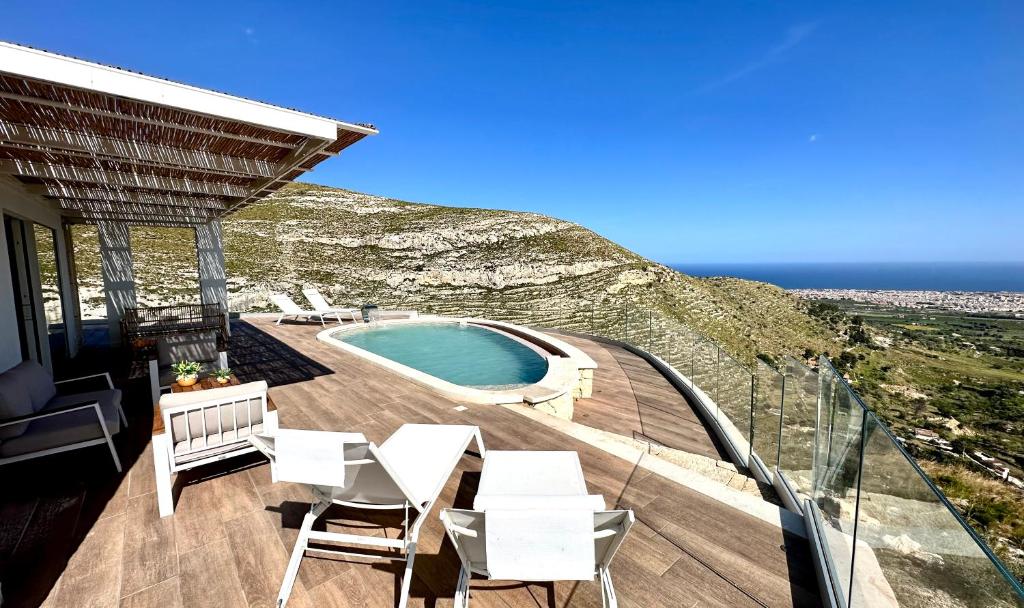 a balcony with white chairs and a swimming pool at Villa Olimpo in Avola