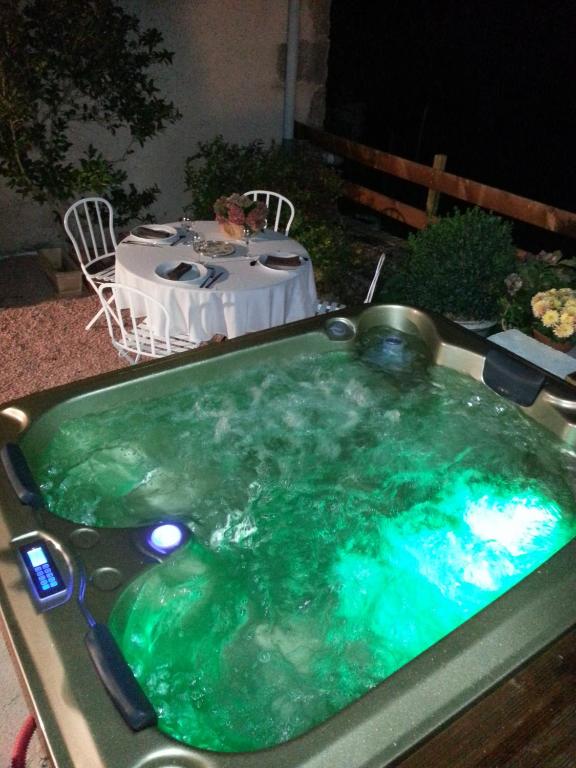 une baignoire jacuzzi avec une table dans l'arrière-cour dans l'établissement Relais St Jacques - Roanne, à Saint-Haon-le-Châtel