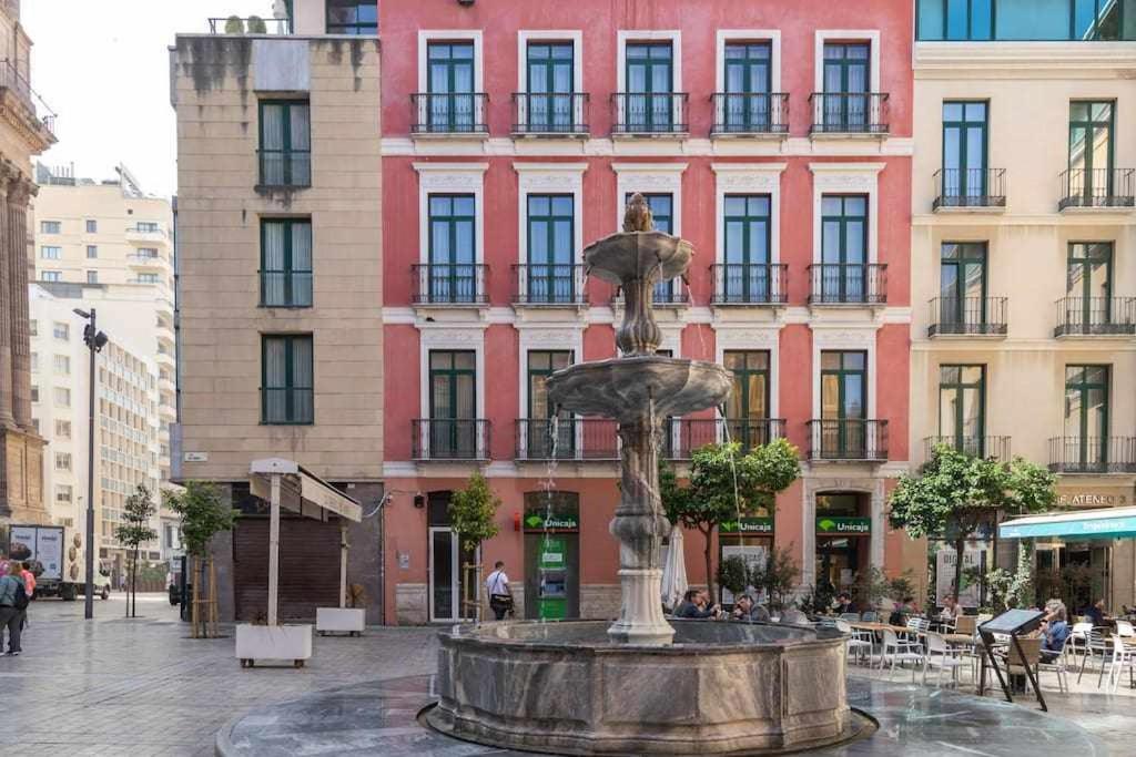 una fuente en medio de una ciudad con edificios en Obispo Apartamento junto a la Catedral de Málaga en Málaga