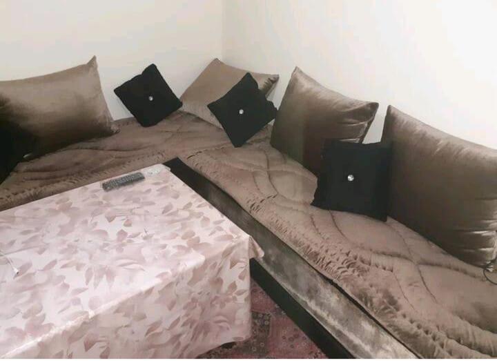 a couch with pillows and a table on it at Apartment bien equipee acasa in Casablanca