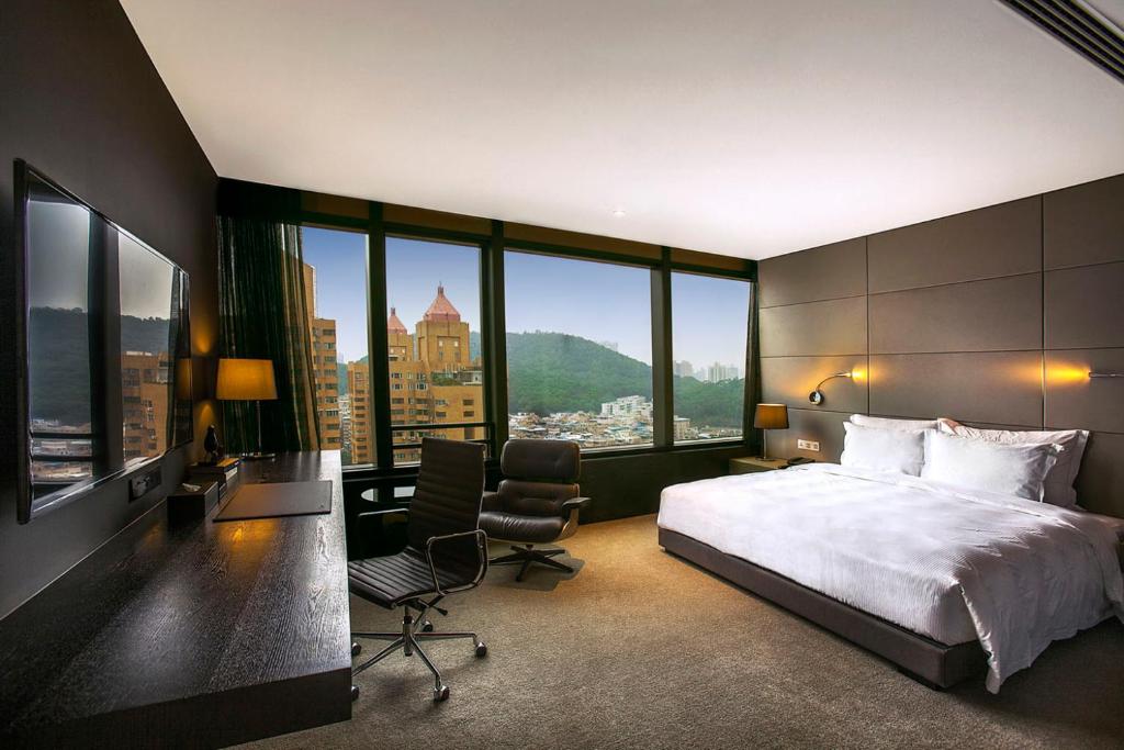 a bedroom with a large bed and a desk and chair at Shenzhen O Hotel in Shenzhen