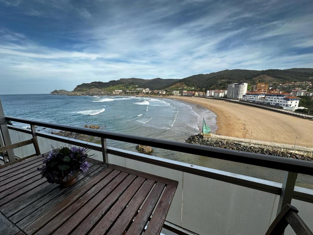 a balcony with a wooden bench and a beach at Bakio, magnificas vistas a la mar in Bakio