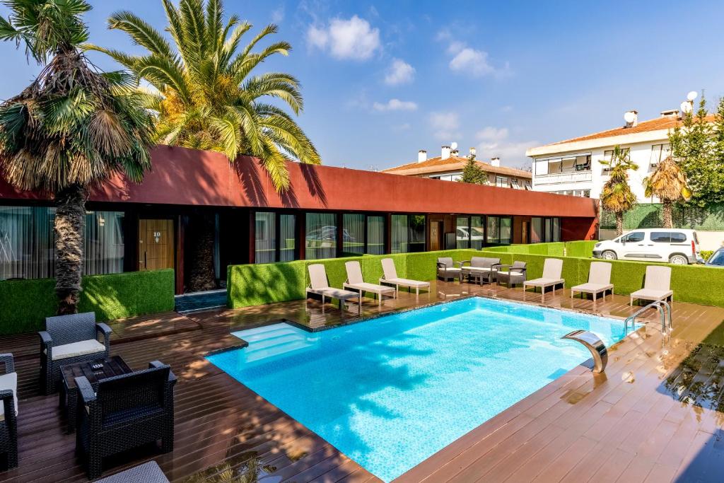 einen Pool mit Stühlen und ein Gebäude in der Unterkunft BayMari Suites Plus Florya in Istanbul