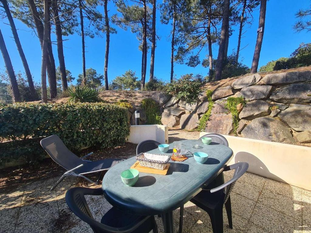 une table bleue avec des chaises sur la terrasse dans l'établissement Maison lumineuse avec piscine, à 2 pas de l'océan - 5 couchages, Saint-Jean-de-Monts - FR-1-224C-125, à Saint-Jean-de-Monts