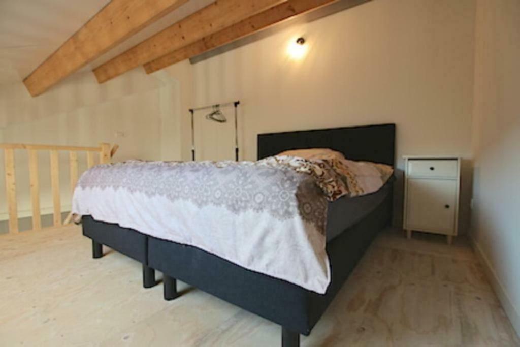 a bedroom with a bed and a wooden floor at Private apartment - Green Heart center NL in Woerden