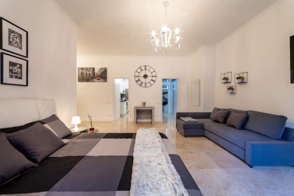 uma sala de estar com um sofá azul e um lustre em San Babila - Luxury Milanese Apartment em Milão