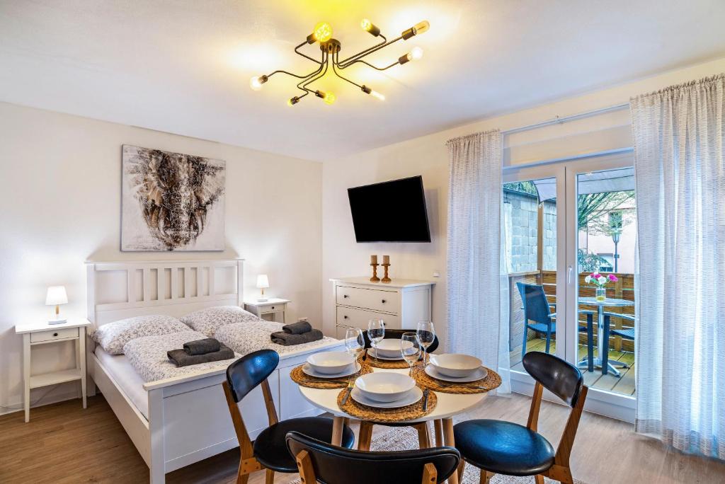 1 dormitorio con 1 cama y 1 mesa con sillas en Apartement Aposto 1 en Oberderdingen