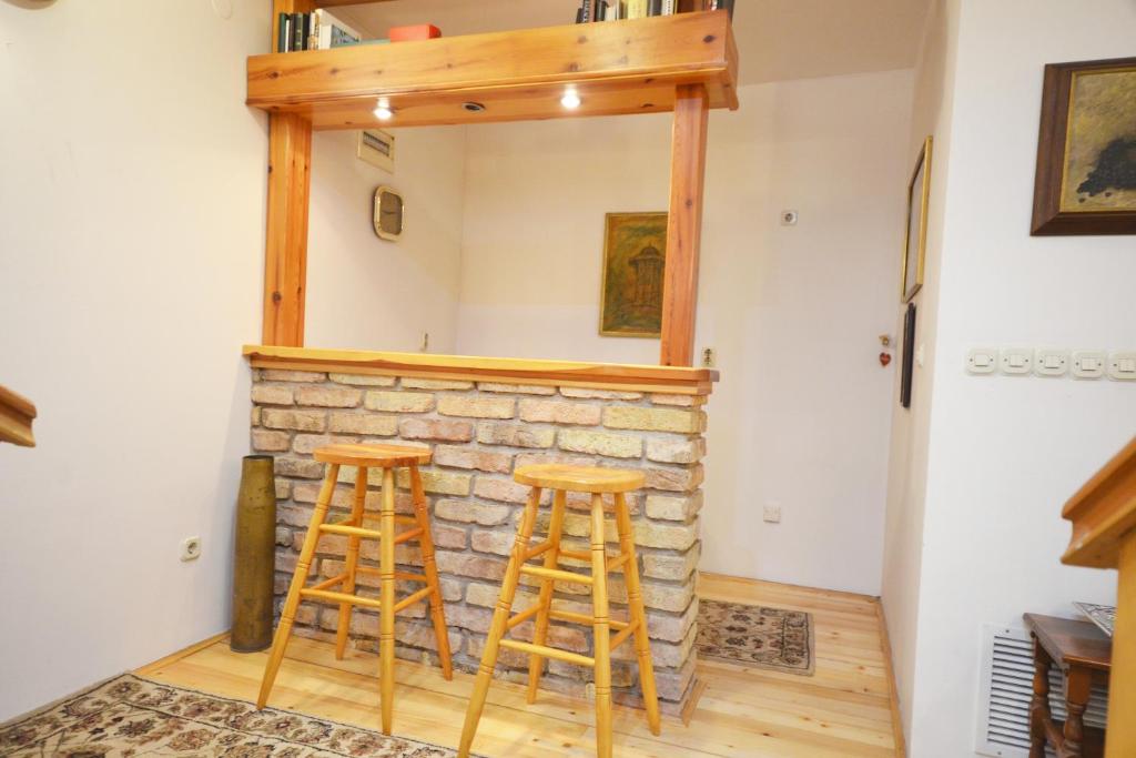 a room with two bar stools in front of a stone fireplace at Apartment Old Town Sarajevo in Sarajevo