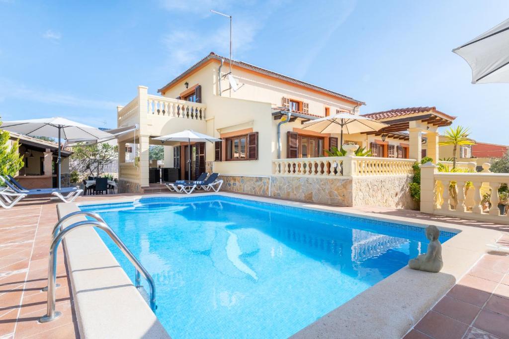 a villa with a swimming pool in front of a house at Villa Manrique in Cala Ratjada