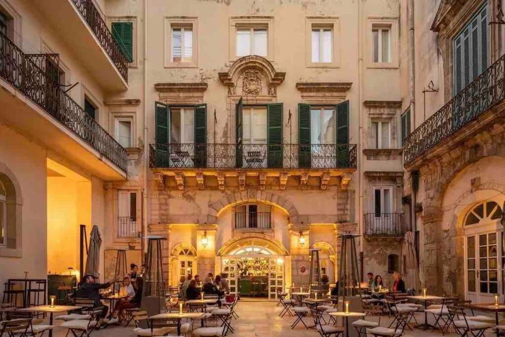 La casa sul Cortile في سيراكوزا: ساحة مبنى به طاولات وكراسي