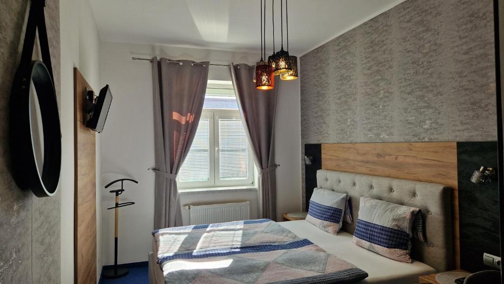 a bedroom with a bed and a window at Penzion PIANO & Apartment Sokolov in Sokolov