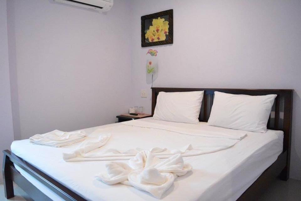 ein weißes Bett mit weißer Bettwäsche und Kissen darauf in der Unterkunft zzeehouse in Ao Nang Beach