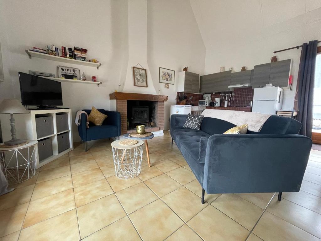 a living room with a blue couch and a fireplace at Iris, les Gîtes de Carlux in Carlux