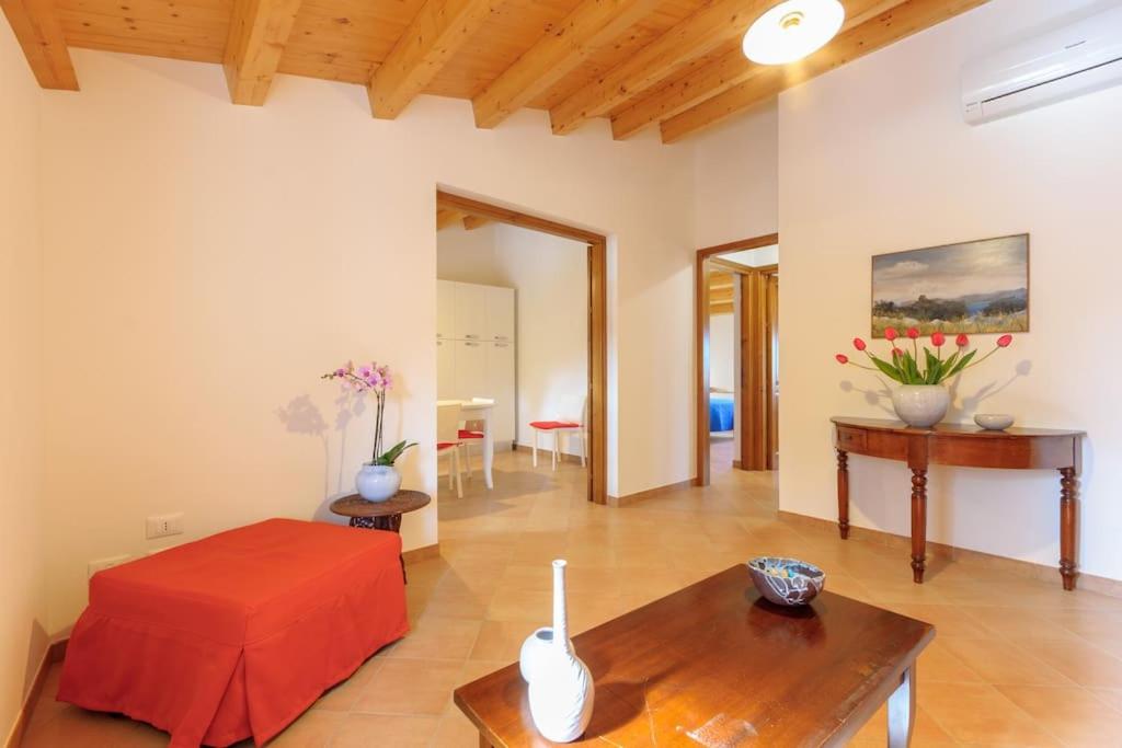 uma sala de estar com uma cama vermelha e uma mesa em Vito nel Baglio em Scopello