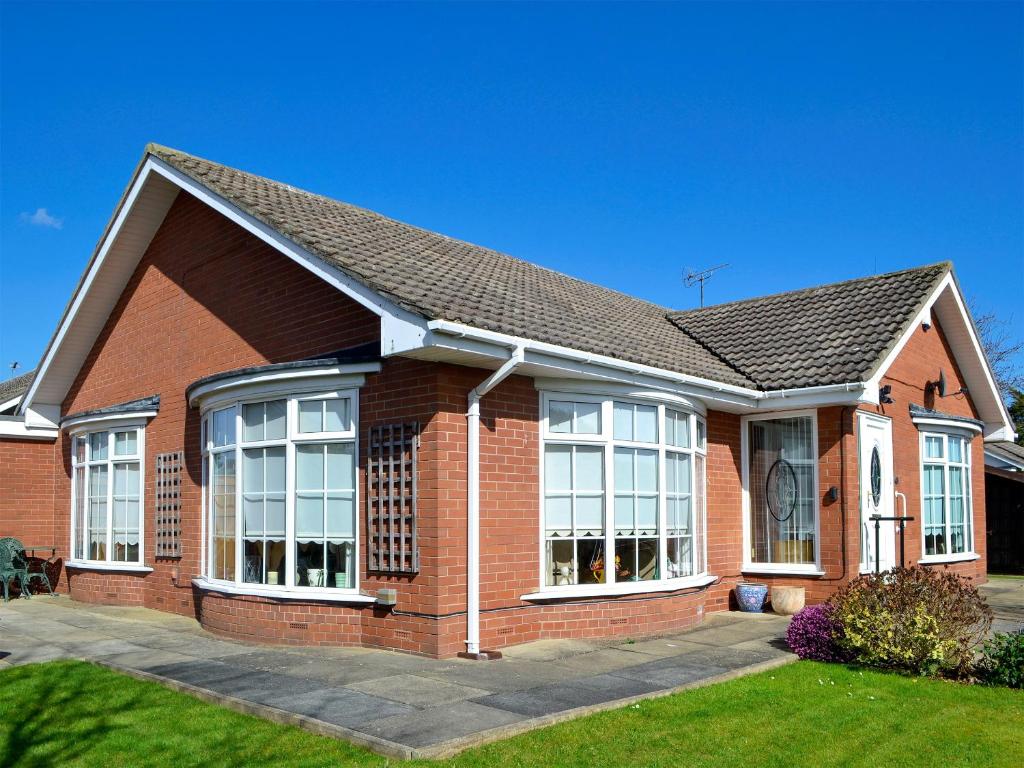 a red brick house with large windows at Corner Cottage in Sewerby