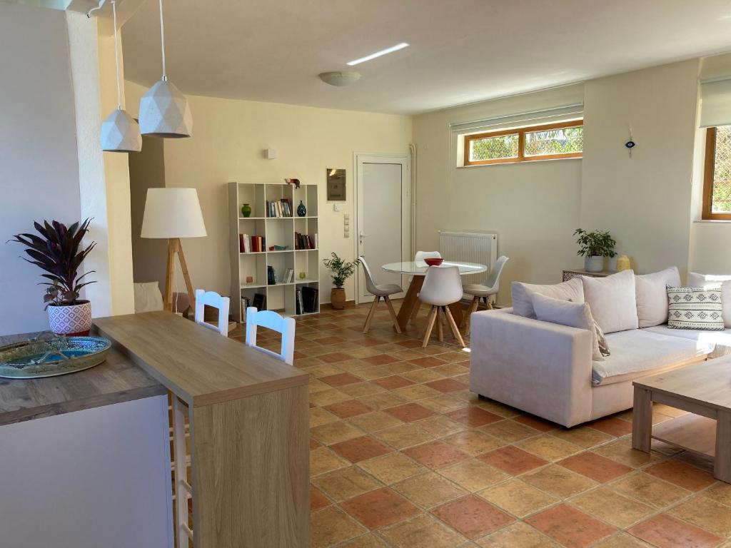 ein Wohnzimmer mit einem Sofa und einem Tisch in der Unterkunft Minoa apartment in the heart of a Cretan village in Atsipopoulo