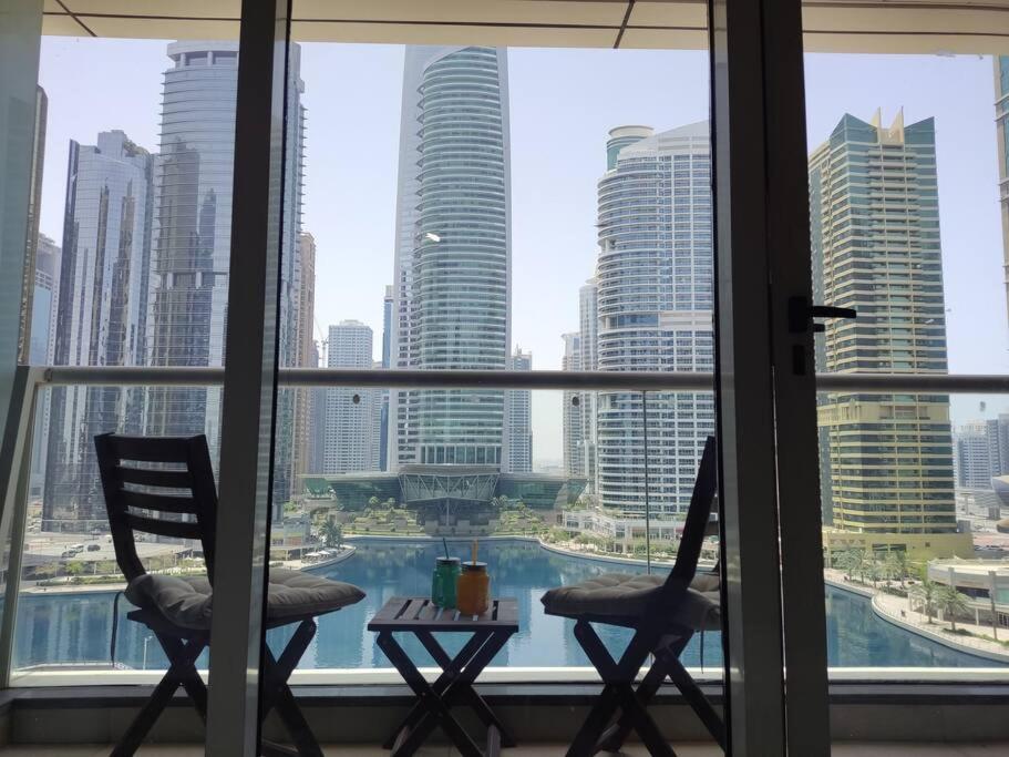 duas cadeiras e uma mesa em frente a uma janela em Waking up with the sea view! em Dubai