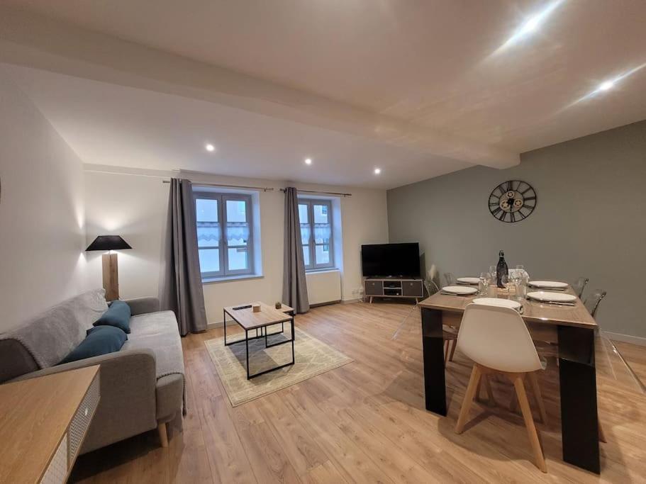 uma sala de estar com um sofá e uma mesa em Appartement Le Duplex em Cluny