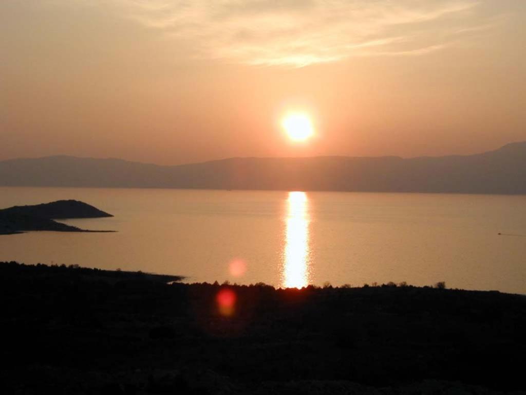 a sunset over a body of water with the sun setting at Apartments Matteo in Omišalj