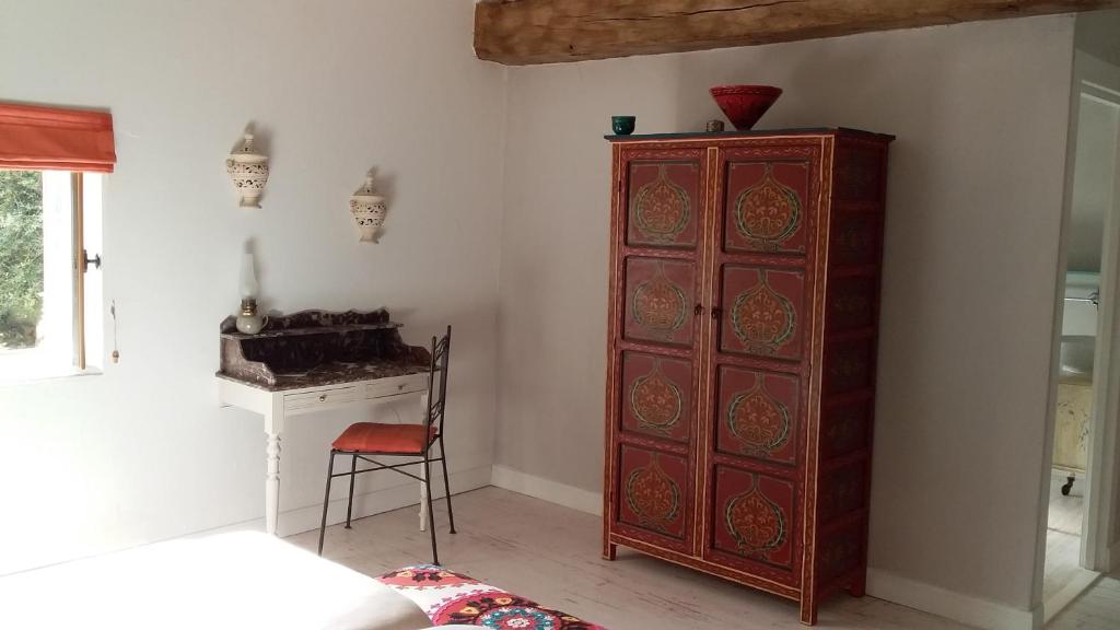 a room with a wooden cabinet and a desk at La Grange de Gournay in  Gournay-Loizé
