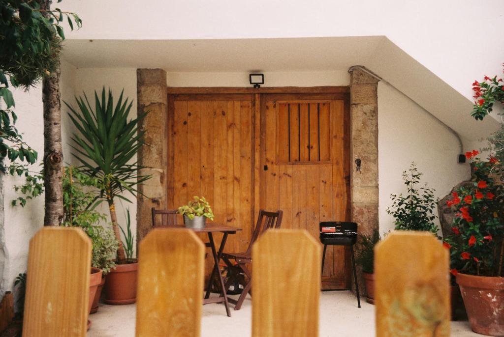 Habitación con puerta de madera y mesa con sillas. en Casa Caliza en Puertas