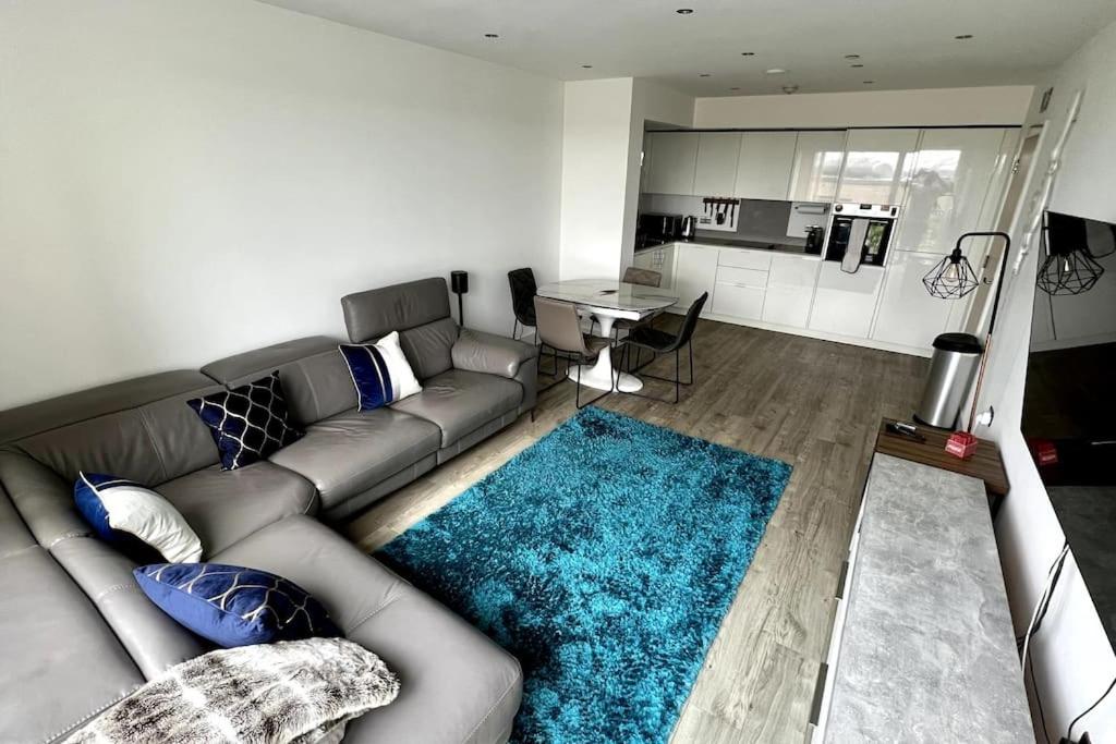 sala de estar con sofá y alfombra azul en Luxury Top Floor Apartment in London, en Londres