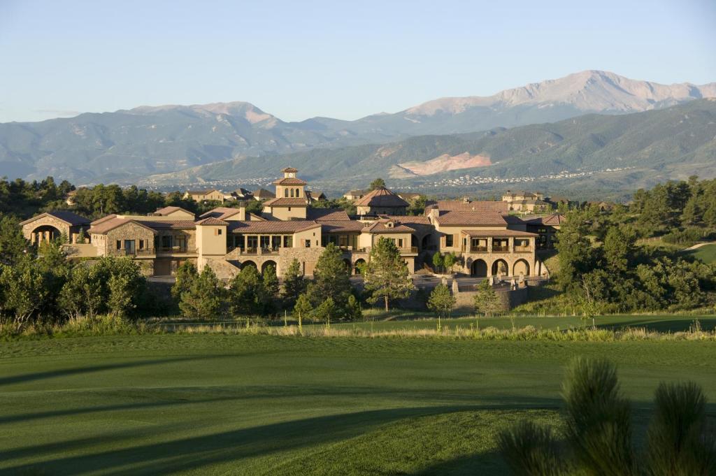 a large building with a mountain range in the distance at The Lodge at Flying Horse in Colorado Springs
