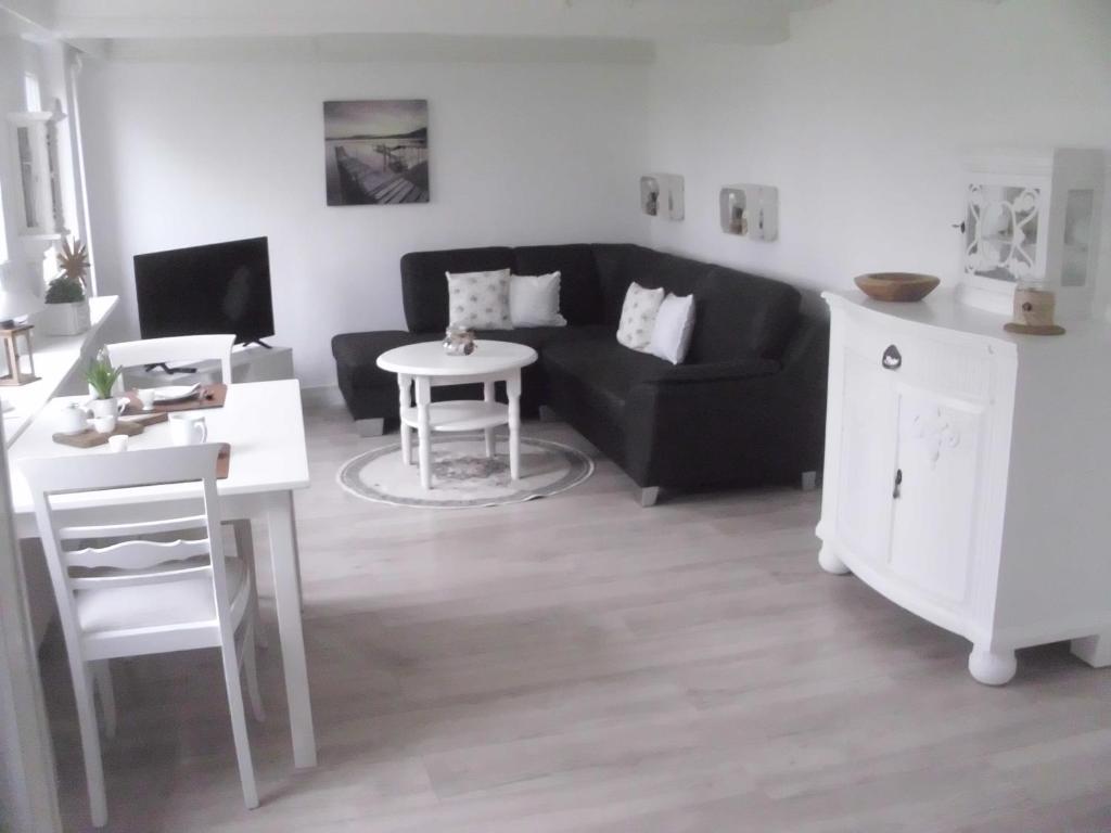 a living room with a black couch and a table at House Louise. in Risum-Lindholm