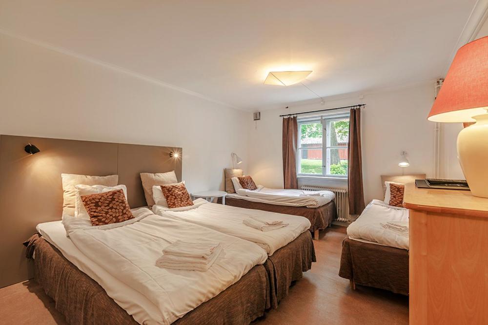een hotelkamer met 2 bedden en een raam bij Gripsholms BnB in Mariefred