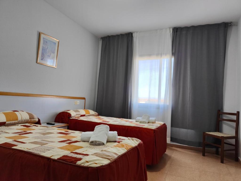 A bed or beds in a room at Hostal Restaurante Venta del Barro