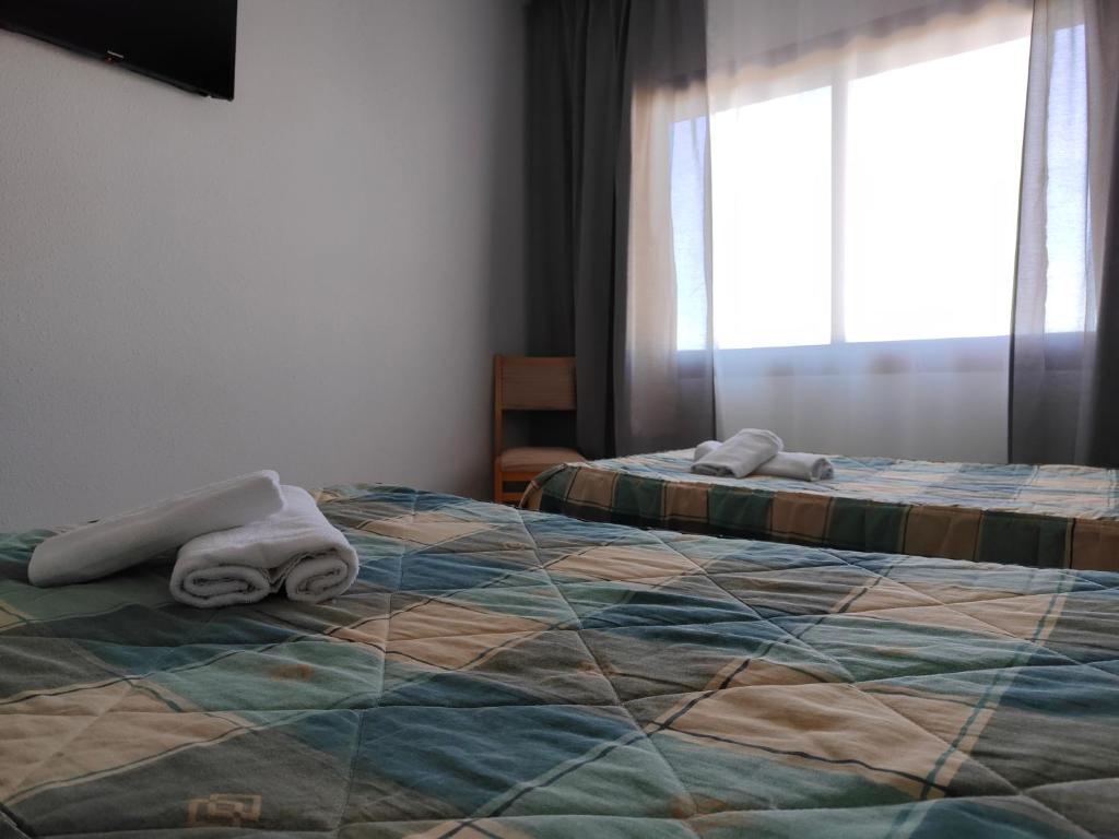 A bed or beds in a room at Hostal Restaurante Venta del Barro