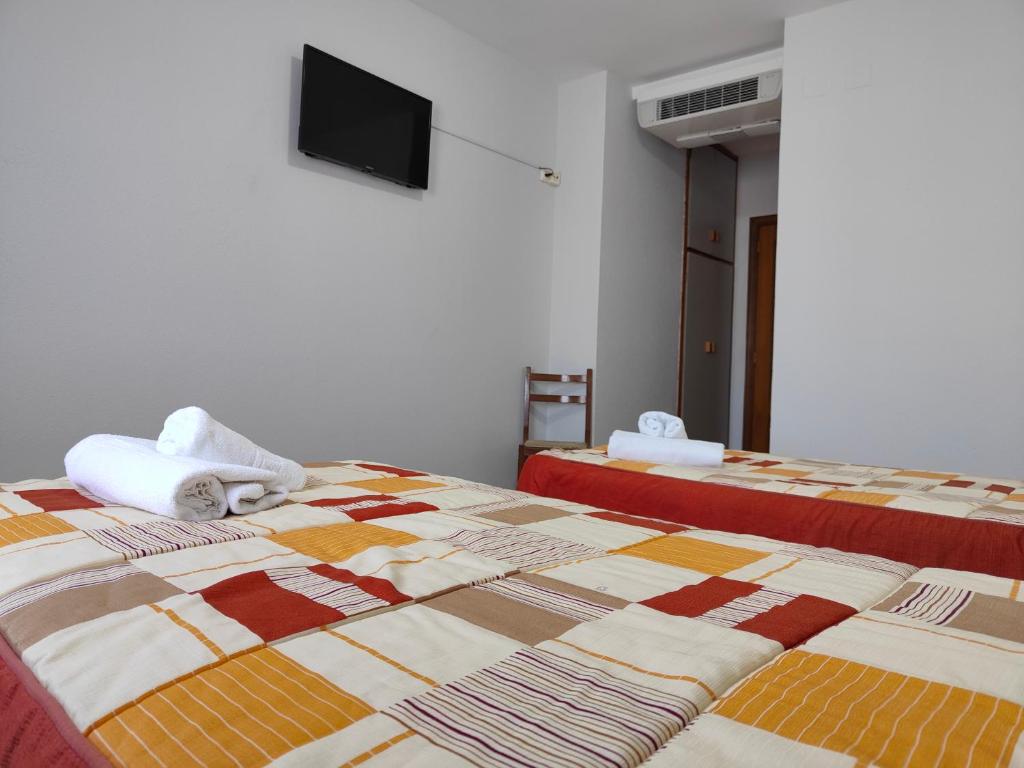 A bed or beds in a room at Hostal Restaurante Venta del Barro