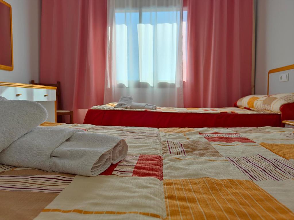 A bed or beds in a room at Hostal Restaurante Venta del Barro