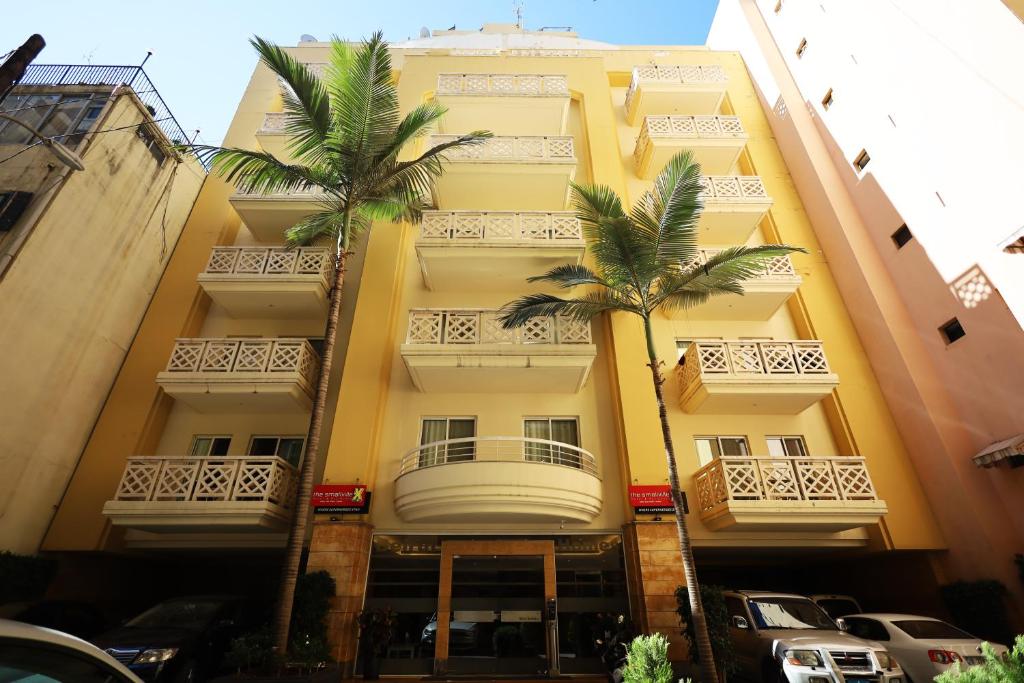 a yellow building with palm trees in front of it at X2 by Smallville in Beirut