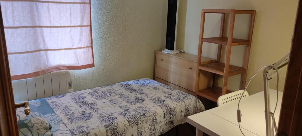 een kleine kamer met een bed en een dressoir bij Habitacion individual en apartamento céntrico in Madrid