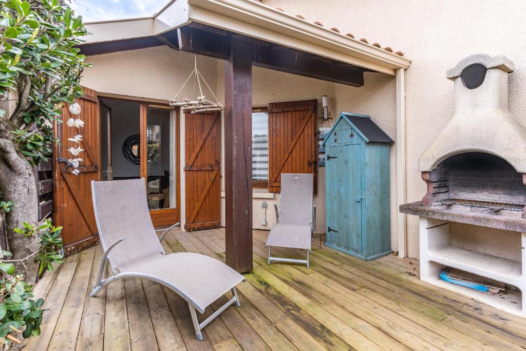d'une terrasse avec 2 chaises et un four extérieur. dans l'établissement Maisonnette biscarosse, à Biscarrosse