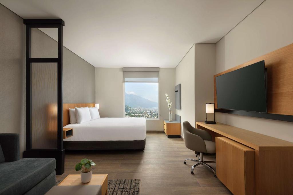 a hotel room with a bed and a flat screen tv at Hyatt Place Monterrey Valle in Monterrey