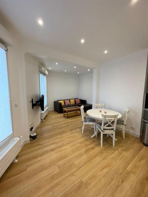 un salon avec une table et un canapé dans l'établissement Paris Centre CLAMART Hôpital PERCY APPART 2 pièces TRÈS Lumineux Grand, à Clamart
