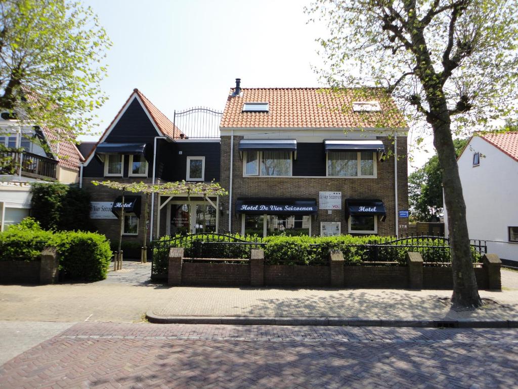 
a large brick building with a tree in front of it at De Vier Seizoenen in Renesse
