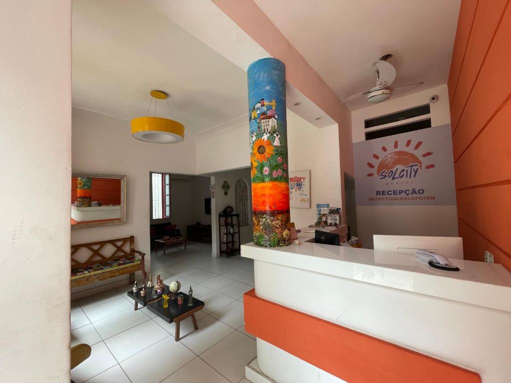 uma sala de estar com uma coluna no meio de uma sala em Solcity Hostel em Salvador